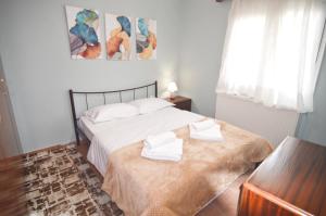 Un dormitorio con una cama con dos toallas encima. en Barbara's country house Kastoria, en Vogatsiko