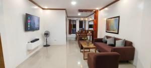 a living room with a couch and a table at Casa Victoria Pension House-Makra in Somosomo +2 photos