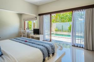 a bedroom with a bed and a large window at Living Asia Resort and Spa in Senggigi