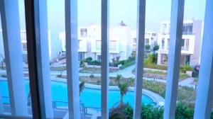 a view of a swimming pool from a window at Fully furnished Townhouse in Abū Rawwāsh