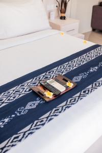 a tray with a remote control sitting on a bed at Living Asia Resort and Spa in Senggigi