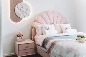a bedroom with a bed with a pink headboard at Family-Friendly four-bedroom Spacious House in Point Cook