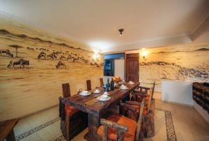ein Esszimmer mit einem großen Gemälde an der Wand in der Unterkunft Gafa House lodge in Sokon