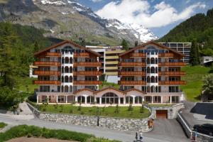a large apartment building in front of a mountain at Residenz Ambassador B01 in Leukerbad