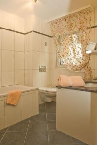 y baño con bañera, aseo y lavamanos. en Residenz Ambassador B01 en Leukerbad
