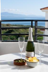 - une bouteille de vin et des verres sur une table avec des chips dans l'établissement Beachfront Apartment with Rooftop Terrace - Manilva - La Duquesa, à Manilva