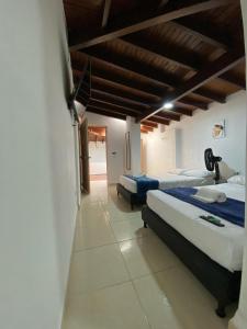 a bedroom with two beds and a ceiling with beams at APARTAHOTEL ESTADIO GOLD in Medellín