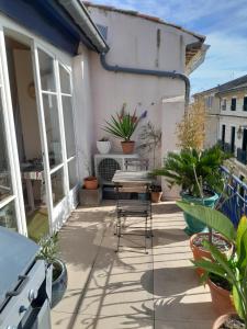 a patio with a table and some plants at Maison dans village du sud in Villeneuve-lès-Béziers