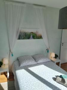 a bedroom with a bed and a window with curtains at Maison dans village du sud in Villeneuve-lès-Béziers
