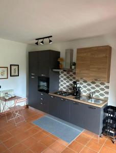 a kitchen with gray cabinets and a table in it at Casa Pruno Rosso in Montemerano +20 photos