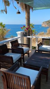 a group of benches sitting on a patio overlooking the ocean at ZBB Villa & Bungalow in Alanya