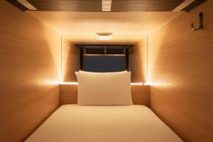 almohada en una habitación pequeña con ventana en Zedwell Capsule Hotel Piccadilly Circus, en Londres