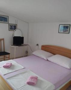 a bedroom with two beds with pink towels on them at Apartments Vlado in Rogač