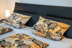a bed with four pillows on it with a headboard at Ferienwohnung im Grünen in Oppenau