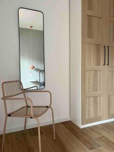 a chair and a mirror next to a door at Milano Fair Apartment in Pero +6 photos