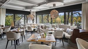 ein Restaurant mit Tischen, Stühlen und Fenstern in der Unterkunft Hotel Central in Hof