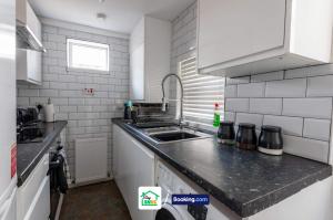 a kitchen with a sink and a counter top at Four Bedroom House in Preston Perfect for Contractors in Preston +14 photos