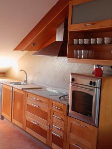 eine Küche mit Holzschränken und einem Herdofen in der Unterkunft Tralla in Corcubión