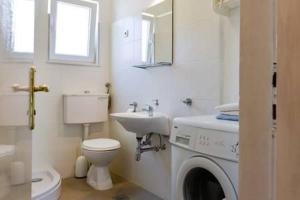 a white bathroom with a sink and a washing machine at Schönes Haus Mit Privatem Garten in Zadar