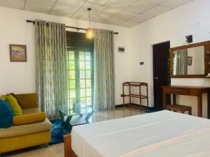 a bedroom with a bed and a couch and a mirror at Villa Vinstar in Katukurunda-Kalutara +12 photos
