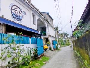 an alley with a building and a yellow car on a street at Hamada's Guesthouse in Baler