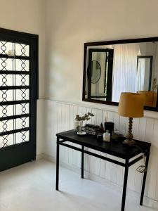 einen schwarzen Tisch mit einer Lampe und einem Spiegel in der Unterkunft Casa Estilo Mediterráneo Jujuy in San Salvador de Jujuy
