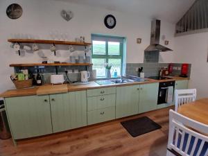 una cucina con mobili verdi e un piano di lavoro di St Kevins Cottage a Hollywood