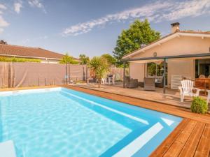 a swimming pool in front of a house at Kerkokos Maison familiale avec piscine in Gujan-Mestras +8 photos