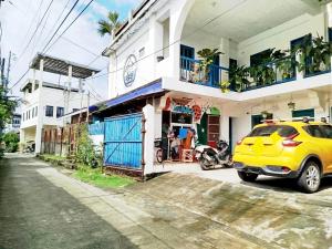 a yellow car parked in front of a house at Hamada's Guesthouse in Baler