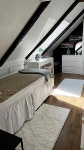 a attic bedroom with a bed and a white table at Villa in historical Uppåkra between Lund and Malmö in Staffanstorp