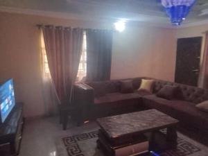 una sala de estar con un sofá y una mesa en B & B Paradise, en Ibadán