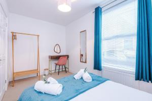a bedroom with towels on a bed with a desk at Stylish 3-Bed City Centre Home in Chester by 53 Degrees Property, Ideal for Groups, Private Parking! in Chester