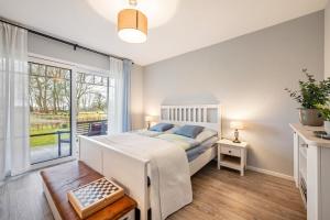 Un dormitorio con una cama y una ventana grande en Ferienstudio Steensen, en Leck