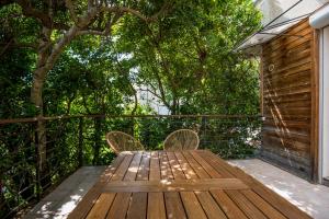 une table et des chaises en bois assises sur une terrasse dans l'établissement le Canopée 3 pers appart F1 terrasse fibre centre-ville, à Millau 12 autres photos