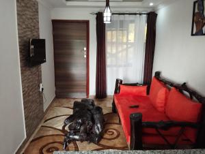 a living room with a red couch and a door at Precious Homestays in Maragoli