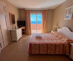 a bedroom with a bed and a view of the ocean at Marbella Beach Resort at Club Playa Real in Marbella +47 photos