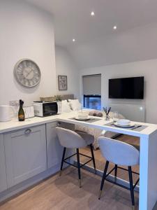 a kitchen with a table with two chairs and a clock at Tithe Cottage in Tamworth