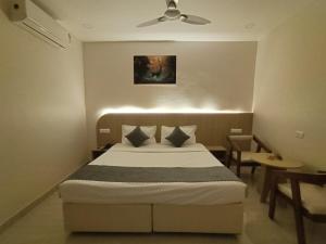 a bedroom with a bed and a ceiling fan at Hotel Meridian Blue in Warangal