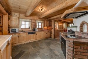 a kitchen with wooden cabinets and a stove top oven at Brandhof - Chalet am Berg in Ramsau am Dachstein