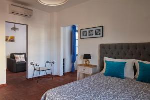 Un dormitorio con una cama con almohadas azules y una silla en Monte do Forno, en Vila Nova de Cacela 25 fotos más