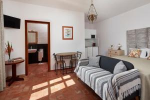 Una sala de estar con una cama, un sofá y una mesa. en Monte do Forno, en Vila Nova de Cacela