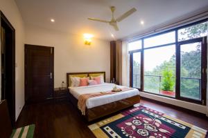 a bedroom with a bed and a large window at Alaya Stays Kasauli Woods Cottage 3 BHK Retreat with Outdoor Lounge & Balcony in Patta +63 photos