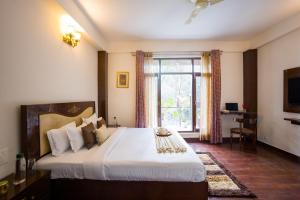 a bedroom with a large bed and a window at Alaya Stays Kasauli Woods Cottage 3 BHK Retreat with Outdoor Lounge & Balcony in Patta