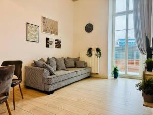 salon z kanapą i dużym oknem w obiekcie AbsyntApartments 24 Rynek Wrocław we Wrocławiu