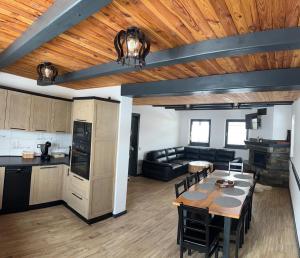 a kitchen and a living room with a table and a couch at Casa Bunicii in Şarul Dornei