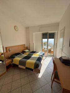 duża sypialnia z 2 łóżkami i biurkiem w obiekcie Hotel Ideal w mieście Arma di Taggia