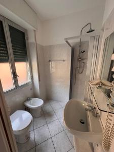 biała łazienka z toaletą i umywalką w obiekcie Hotel Ideal w mieście Arma di Taggia