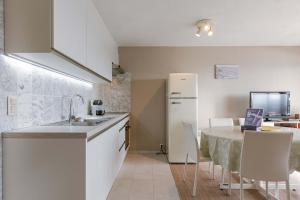 une cuisine avec une table et un réfrigérateur blanc dans l'établissement Cozy studio with harbor view in Blankenberge, à Blankenberge
