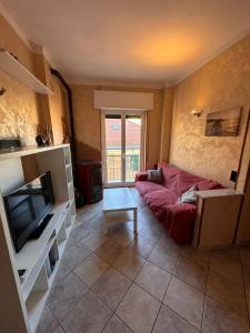 salon z czerwoną kanapą i telewizorem w obiekcie Hotel Ideal w mieście Arma di Taggia
