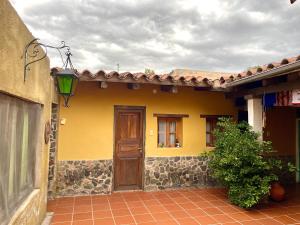 a yellow house with a door and a window at Hostel Alelí in Cafayate